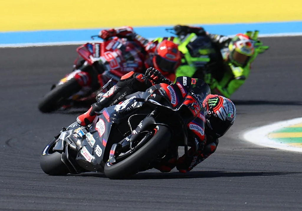 Carrera de MotoGP en el Gran Premio de Brasil 2026 con Marco Bezzecchi liderando en una curva con Aprilia.